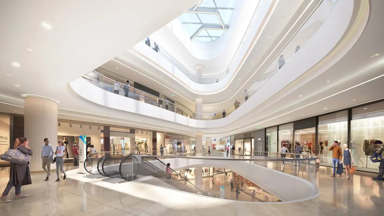 Foto de pátio interno central de um grande shopping center, rodeado de lojas e cheio de pessoas caminhando por ele