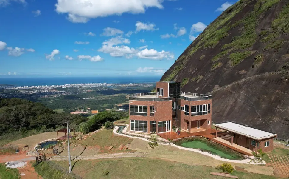 Casa localizada em cima de um morro, com vista privilegiada para a paisagem.