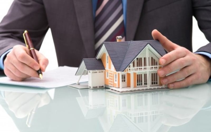 Arquiteto analisando documentos de imóvel.