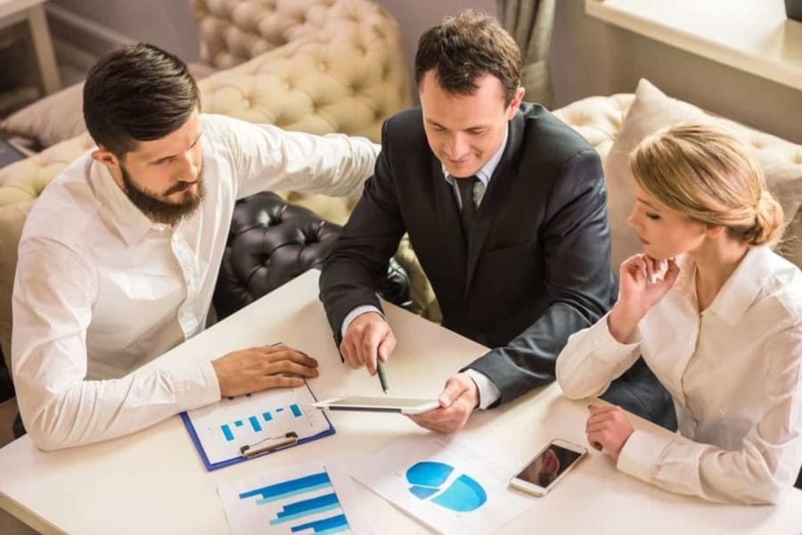Pessoas analisando documentos e gráficos para planejamento de uma holding patrimonial