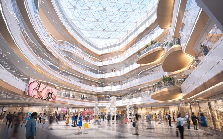 Foto de pátio interno central de um grande shopping center, rodeado de lojas e cheio de pessoas caminhando por ele