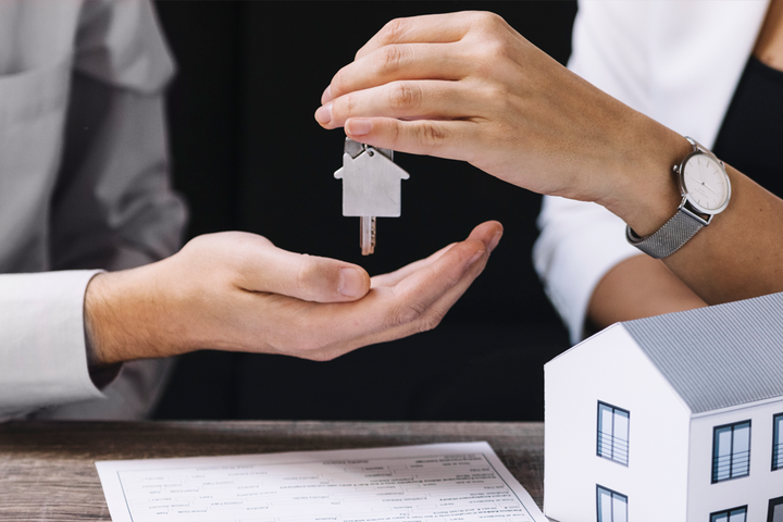 Pessoa entregando chaves de um imóvel a outra pessoa.