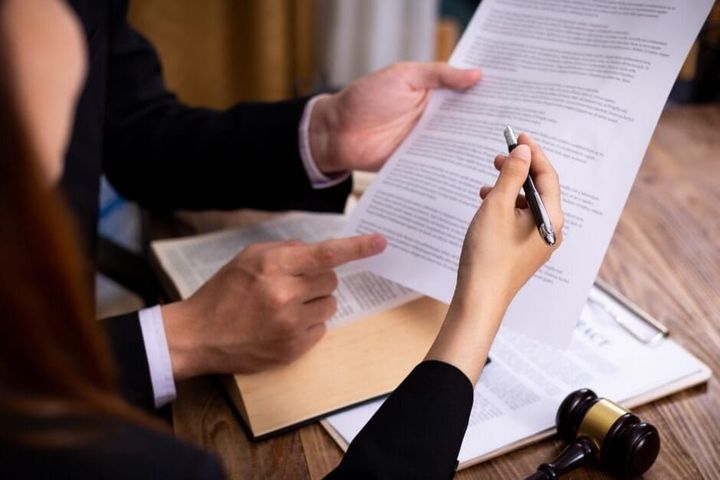 Pessoas analisando Escritura Pública do Imóvel.