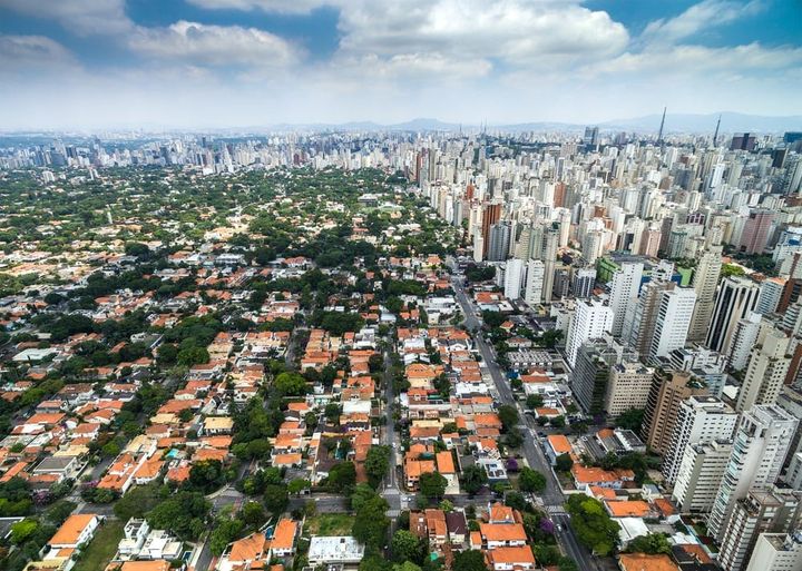 Imagem aérea de cidade mostrando o contraste de duas regiões vizinhas reflexos da especulação imobiliaria. 