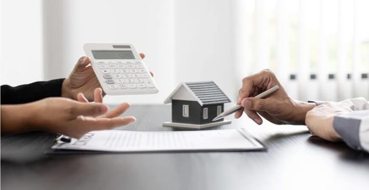 Duas pessoas calculando impostos em negociação do imóvel.