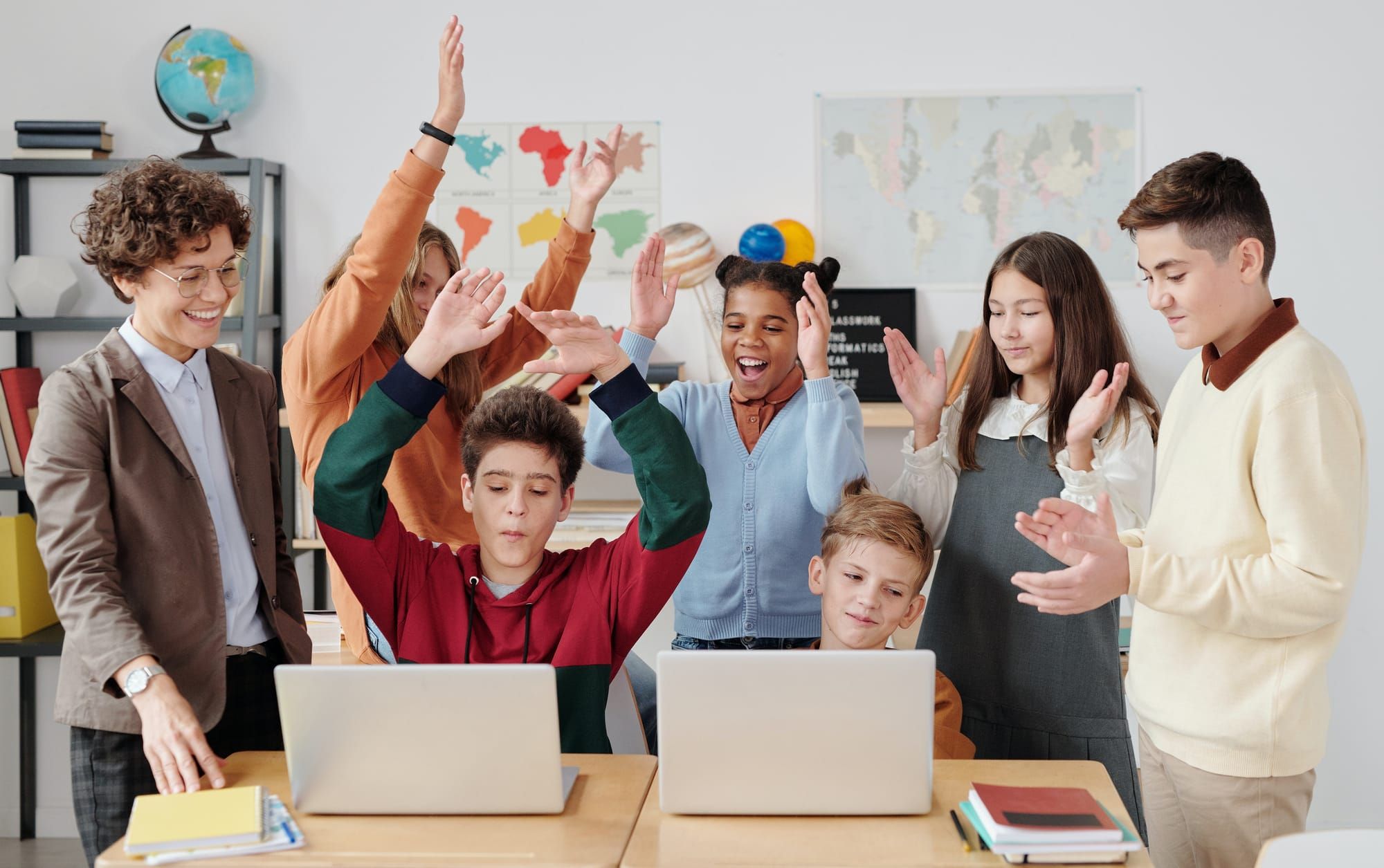 Future teacher skills; a teacher stainding next to her happy students; digital skills; digital education