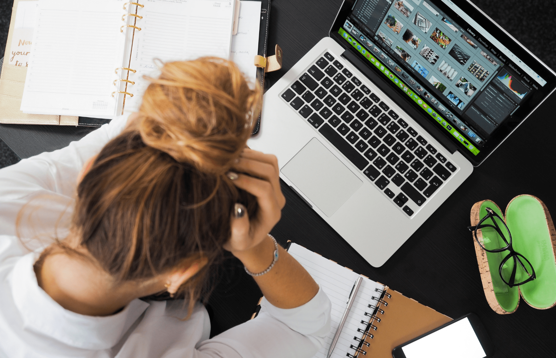 female business owner experiencing anxiety over a laptop and some papers