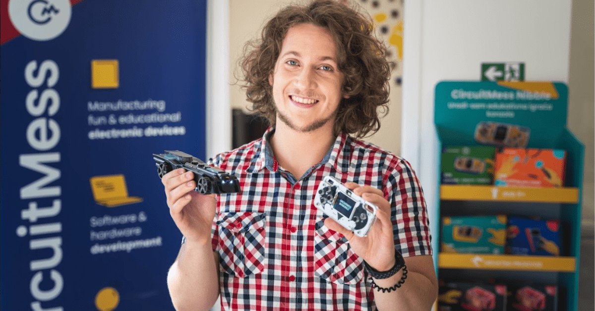 Portrait picture of Albert Gajsak holding CircuitMess BatMobile, part of their STEM education kit