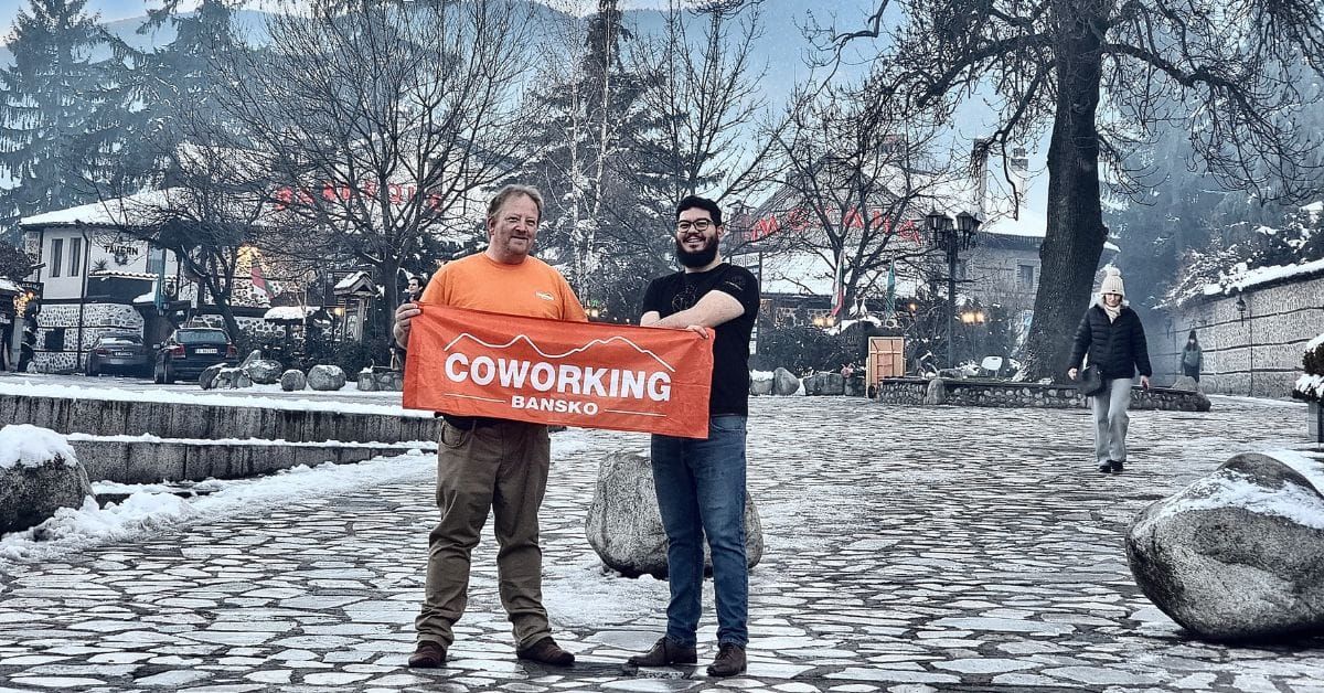 Two men holding an orange banner in Bansko, Bulgaria