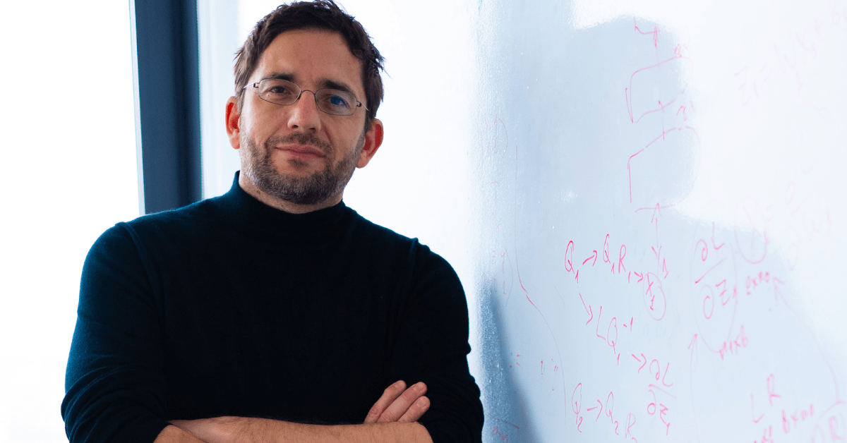 Portrait of Martin Vechev, founder of INSAIT leaning at a white board written in formulas