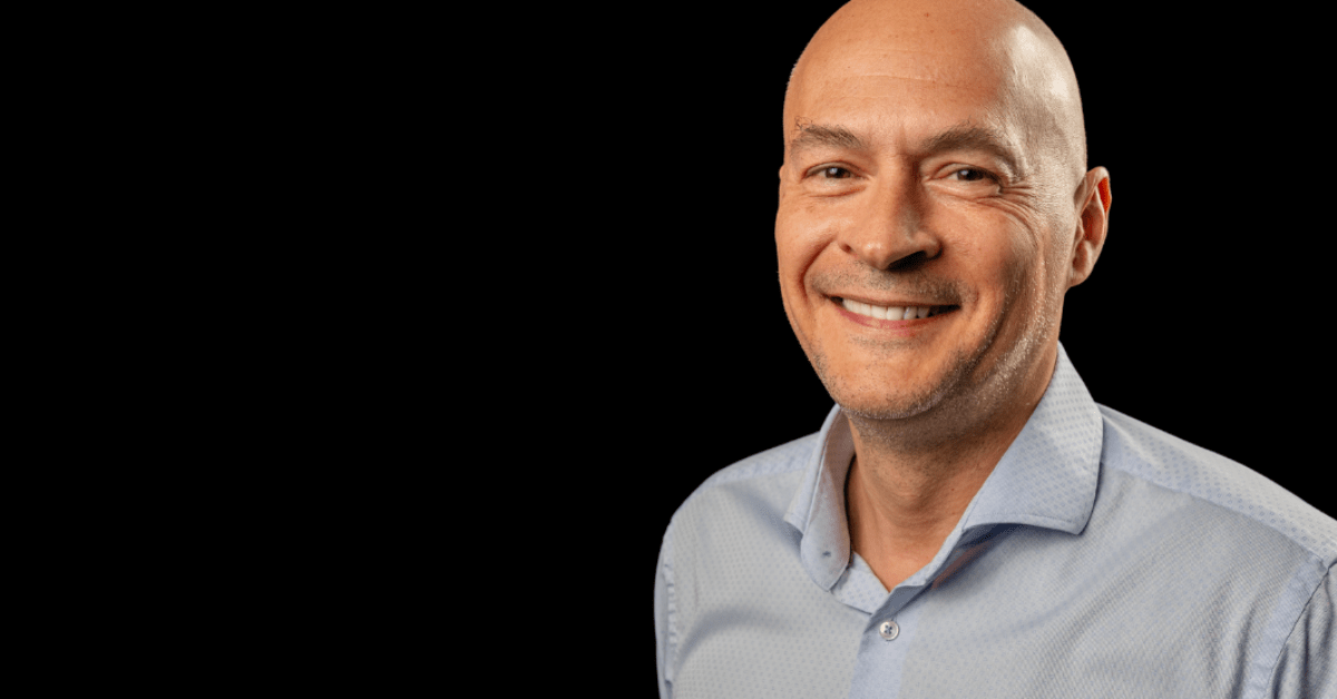 portrait photo of george dochev, co-founder of lucidlink smiling on black background