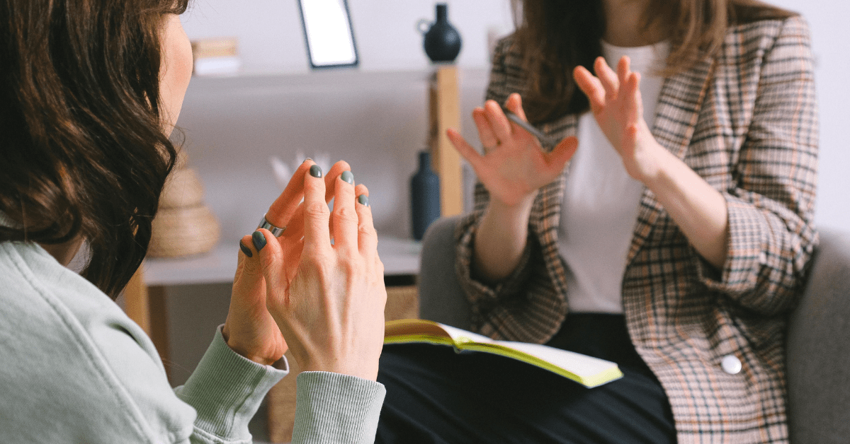 Two people talking, hand in focus