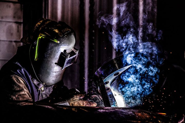 Oilfield welder at work — representing the labor and capital intensity of upstream operations during a market crisis