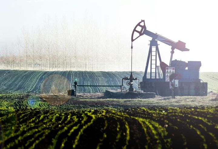 Oil pumpjack in agricultural landscape