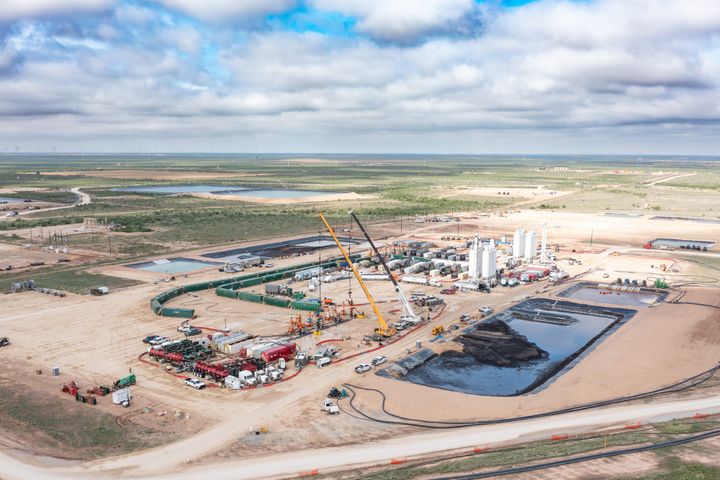 Industrial frac pumping equipment and pipes at an oilfield completion site