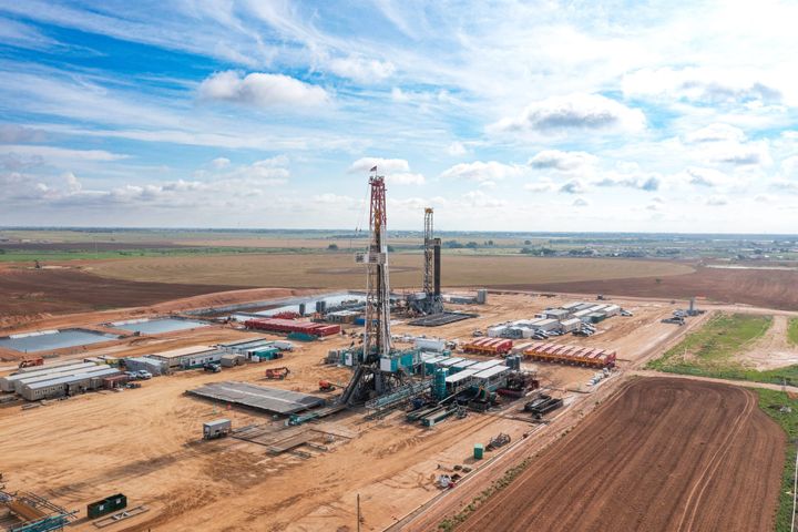 Wide aerial view of Permian Basin drilling rig against cloudy sky