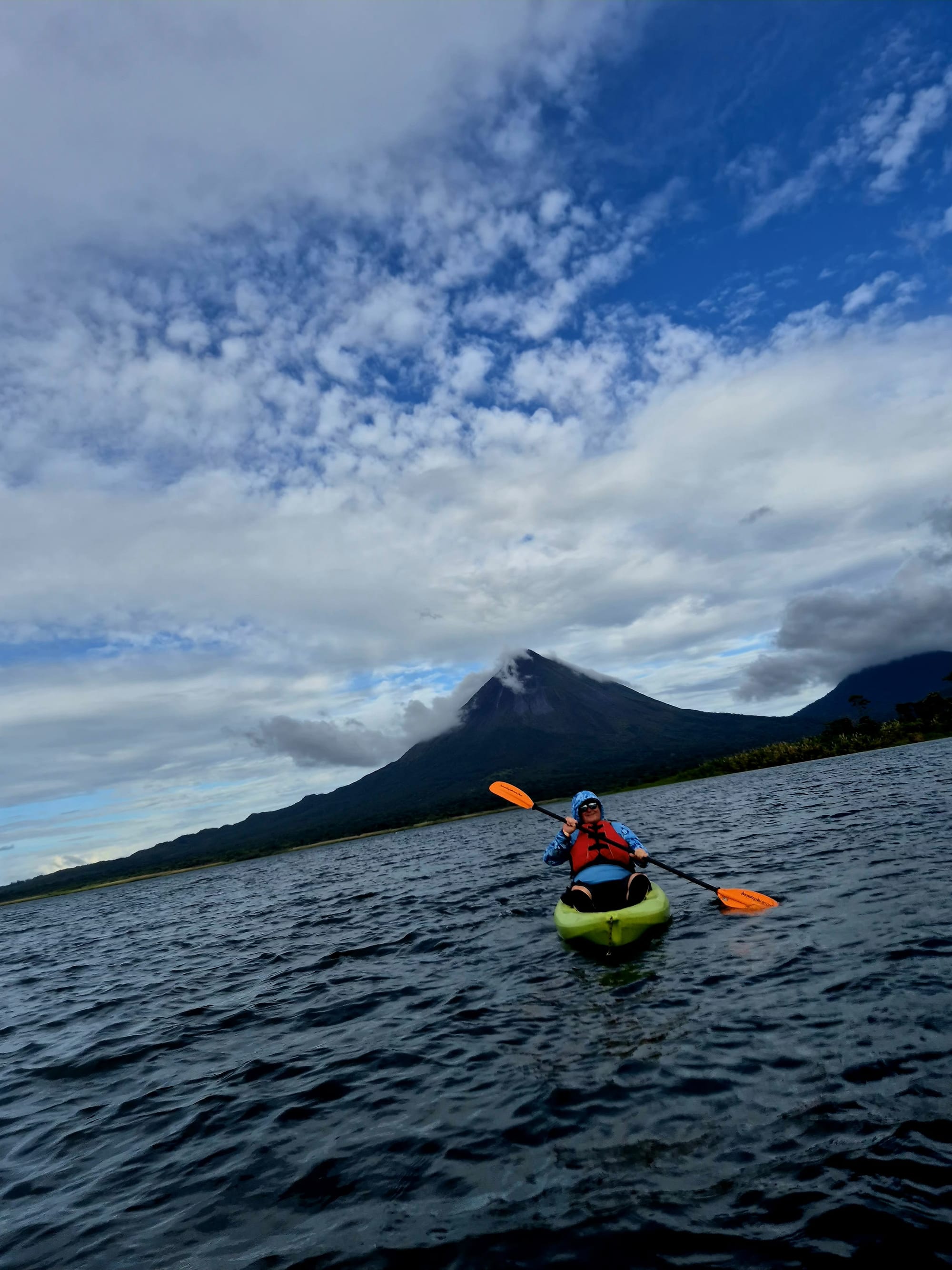 Kayaking on Lake Arenal with Arenal Volcano filling the horizon — calm water, vast scale, and an unmistakable sense of where we were.