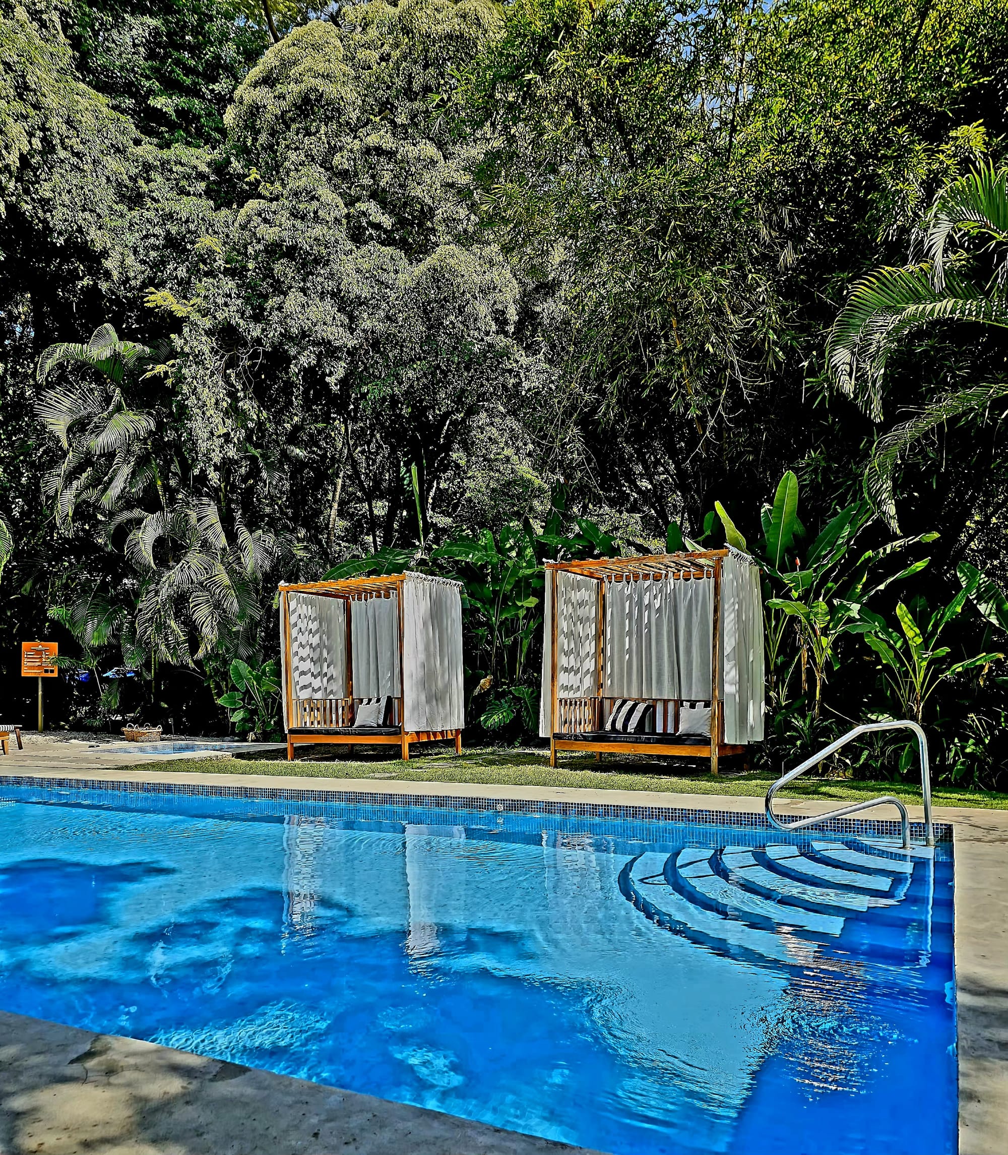 Nya Hotel — The jungle-framed pool at Nya, where quiet mornings drift into slow afternoons, cabanas sit tucked into the greenery, and Montezuma’s laid-back rhythm takes over