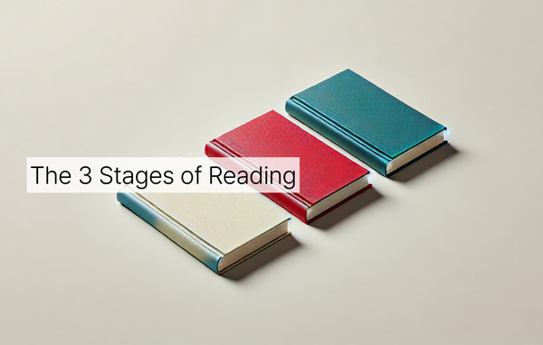 Three closed books — white, red, and blue-green in color — lying on an off-white surface with the text "The 3 Stages of Reading" over it in banner form.