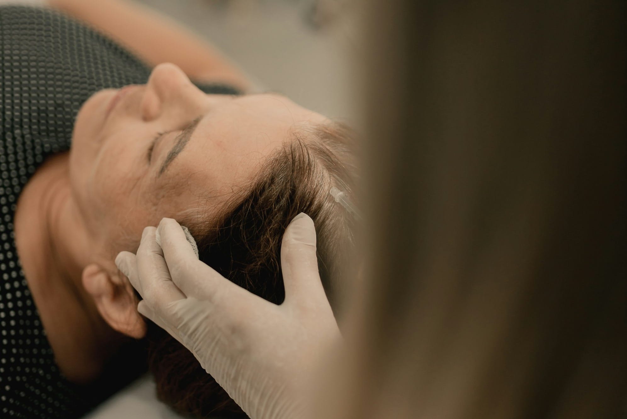 A woman getting her hair cut by a hair stylist