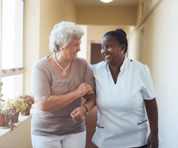 Elderly woman walking with health aide