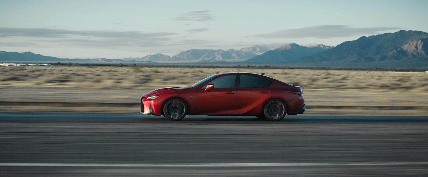 2025 Lexus IS 500 F SPORT Performance in Infrared driving through the desert with mountains in the background