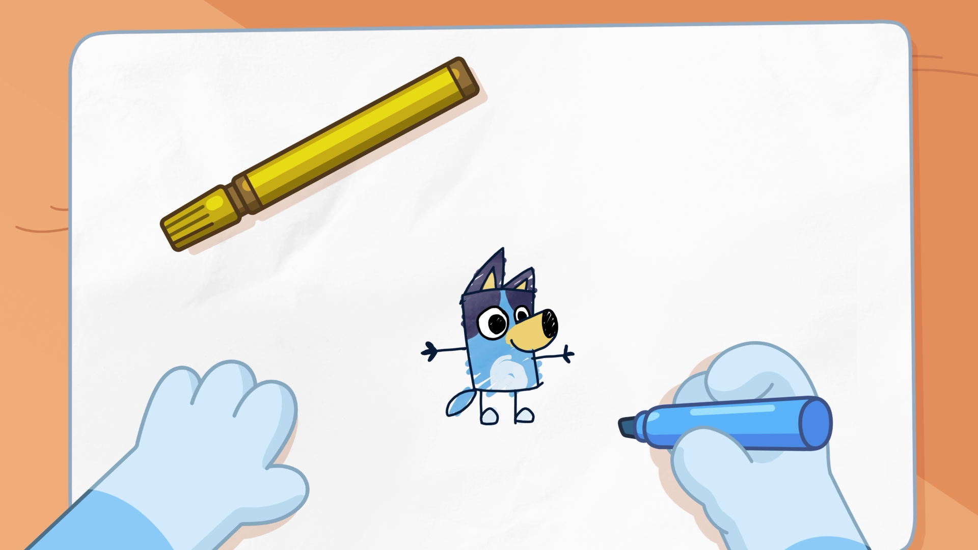 Animated hands drawing a small Bluey character on white paper using a blue marker, illustrating the creative process behind Bluey’s Quest for the Gold Pen.