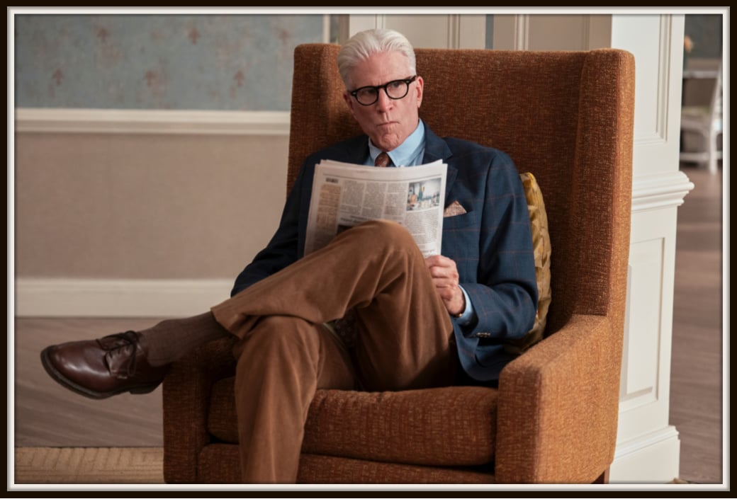 Ted Danson’s character in A Man on the Inside ponders a news article in this captivating scene. The blend of his focused expression and stylish wardrobe brings depth to the moment, making it a standout in the series.