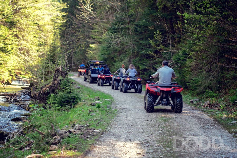 A tour group travels on ATVs and UTVs on the mountains