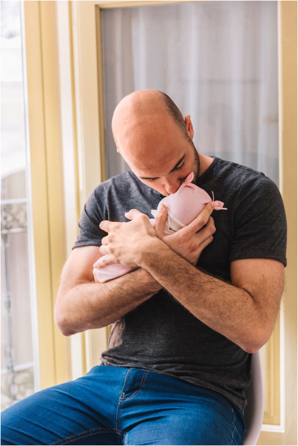 A Dad hold his newborn and he wonders how other Dads Fight for Better Paternity Leave