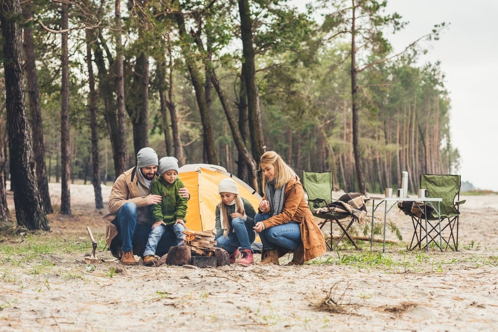 small family camping near the beach with a campfire