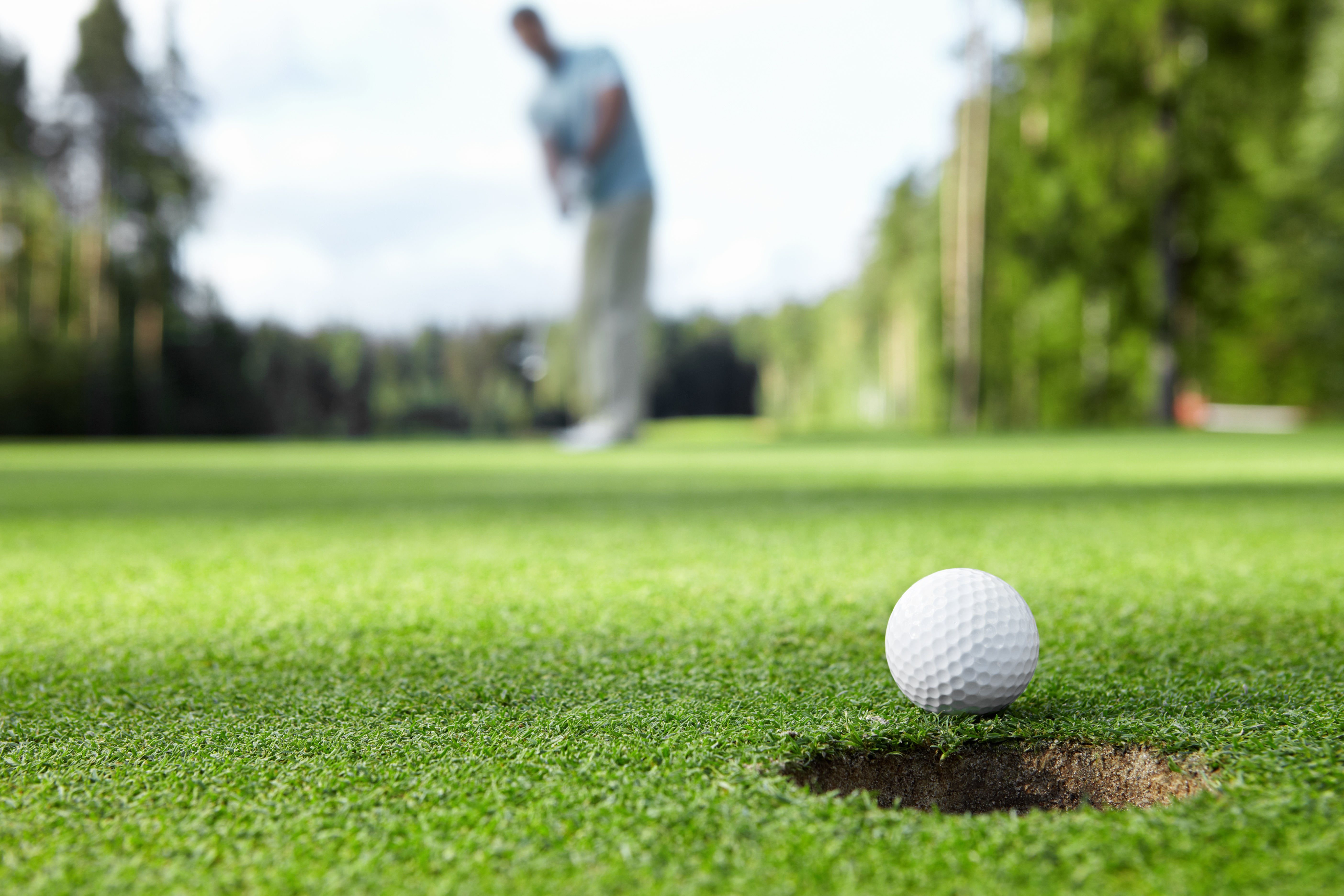 male putting on a golf green