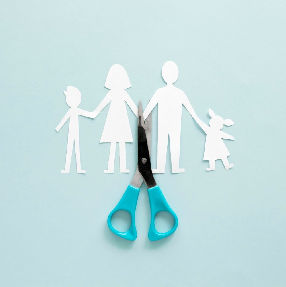 Paper family being cut in half with scissors - divorce