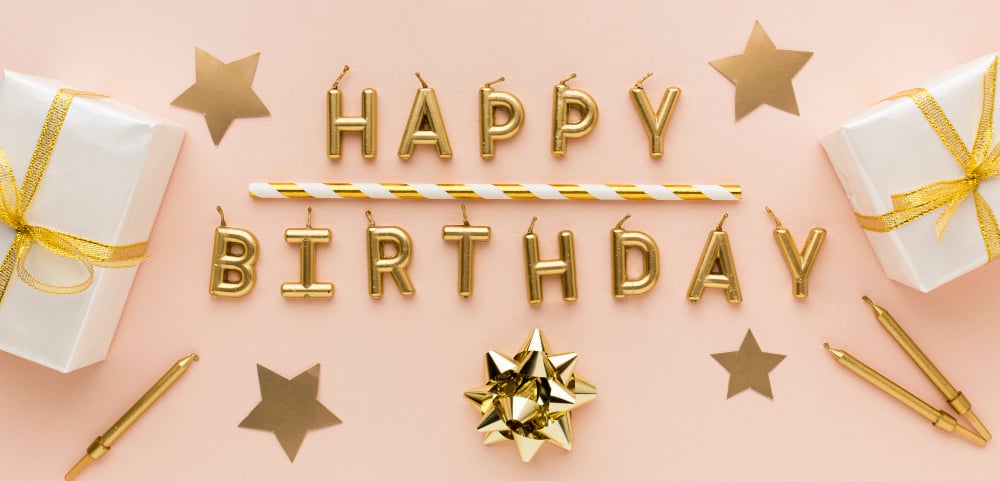 Golden candles with happy birthday and gifts