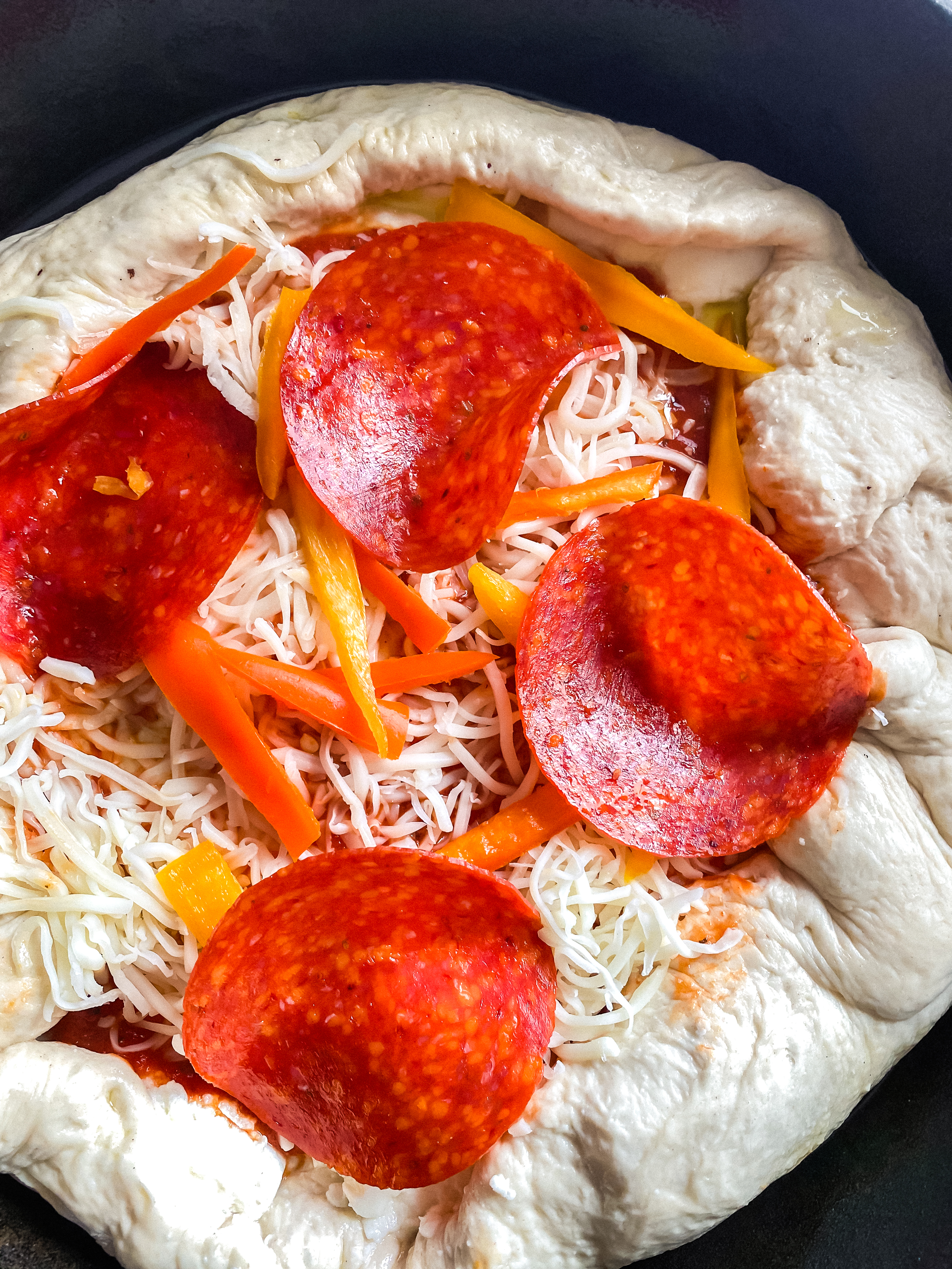 adding toppings to a Pizza sauce - Stuffed Crust Cast Iron Pizza