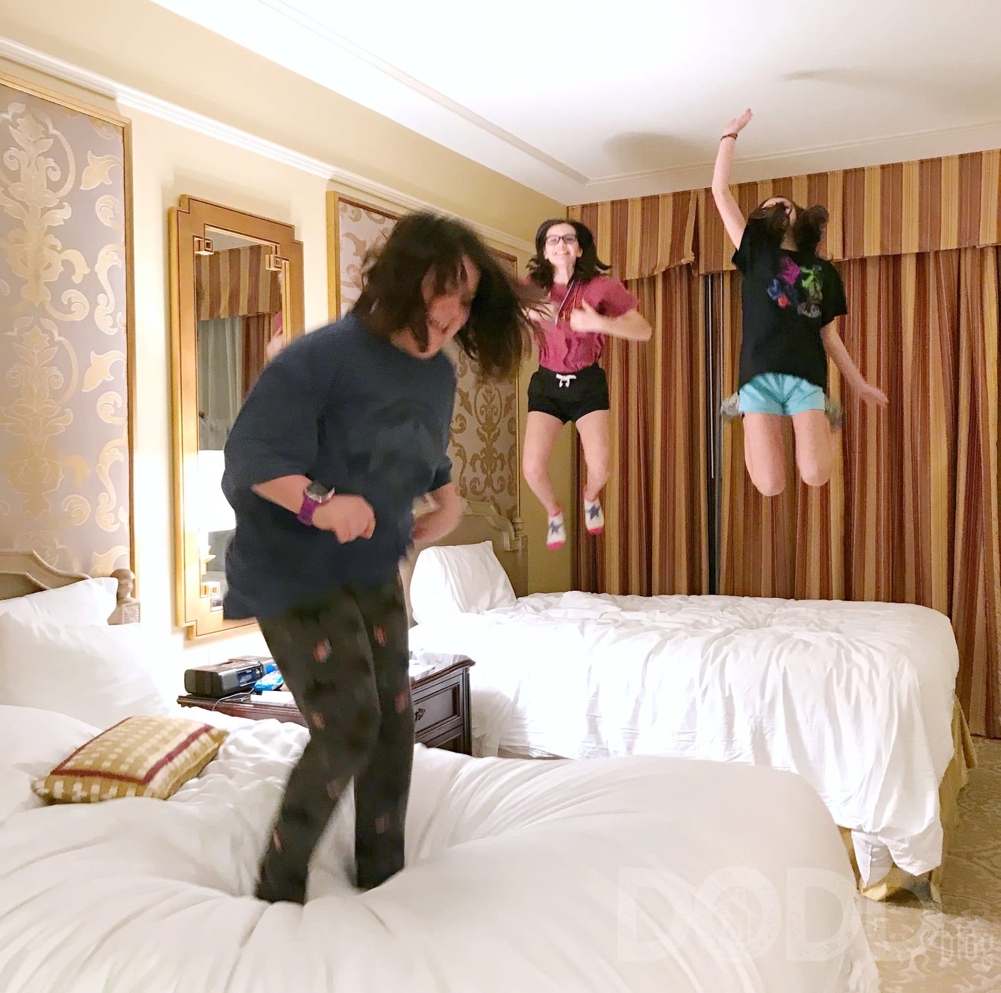 Kids jumping on hotel bed