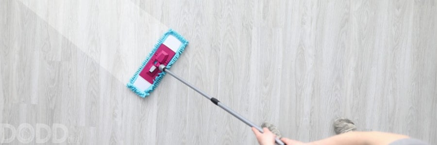 male hand holding plastic mop wash dirty floor.
