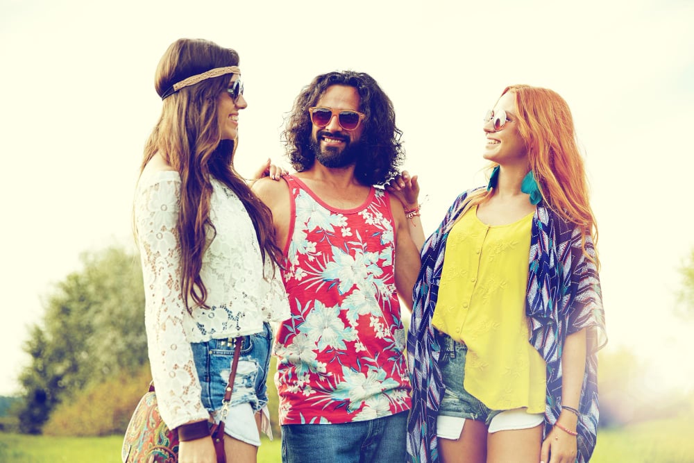Nature, summer, youth culture and people concept - smiling young hippie friends in sunglasses talking outdoors

