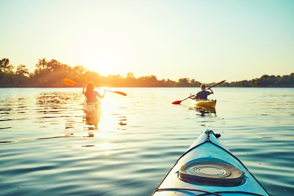 People kayak at summer camp during sunset in the background. have fun in your free time.