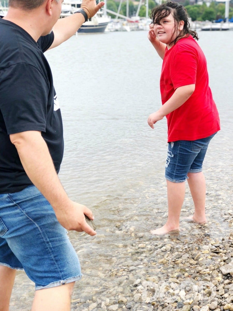 dad and daughter skipping rocks in Lake Michigan