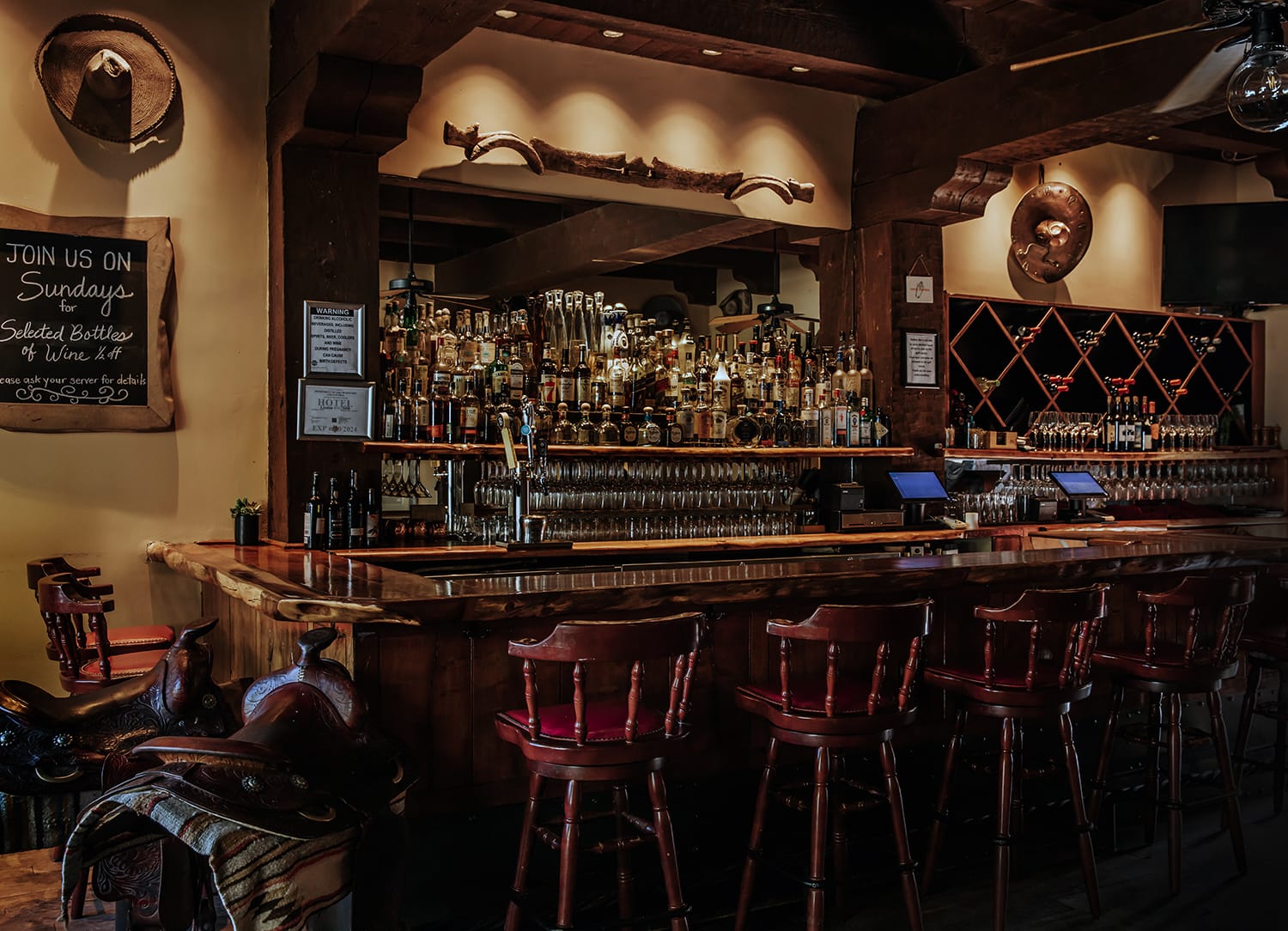 Rustic Southwestern bar with wood accents and wine displays at Tubac Golf Resort