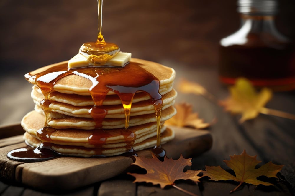 Photo a stack of pancakes with syrup dripping down the side.
