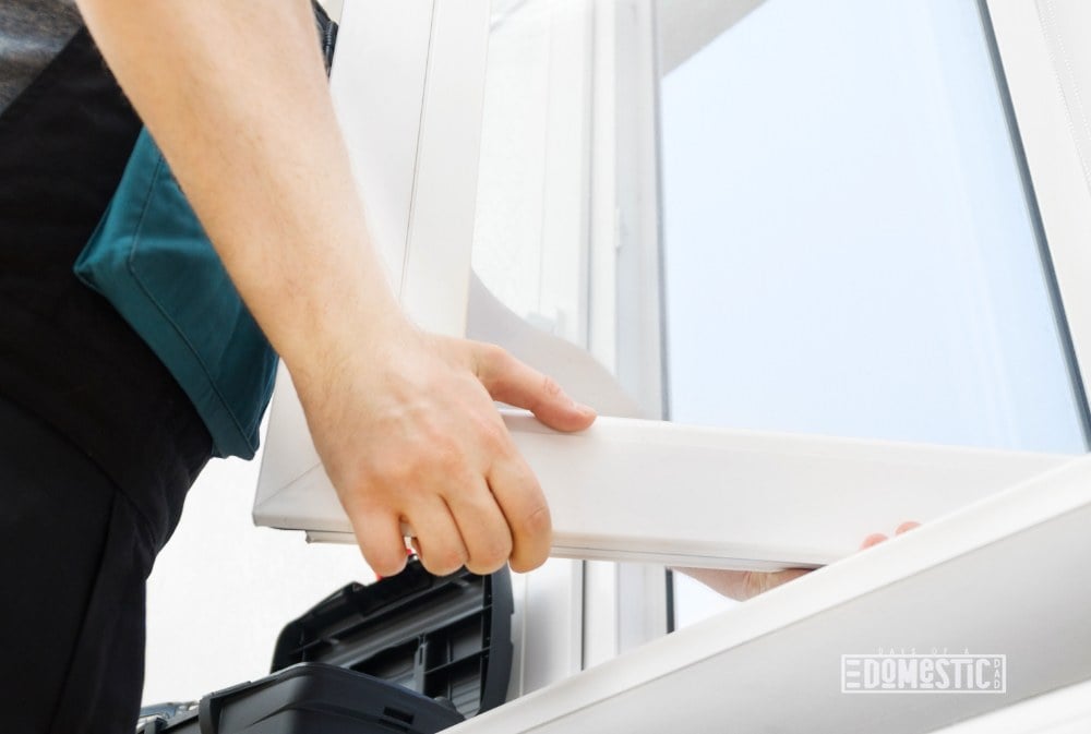 Professional handyman installing window at home.