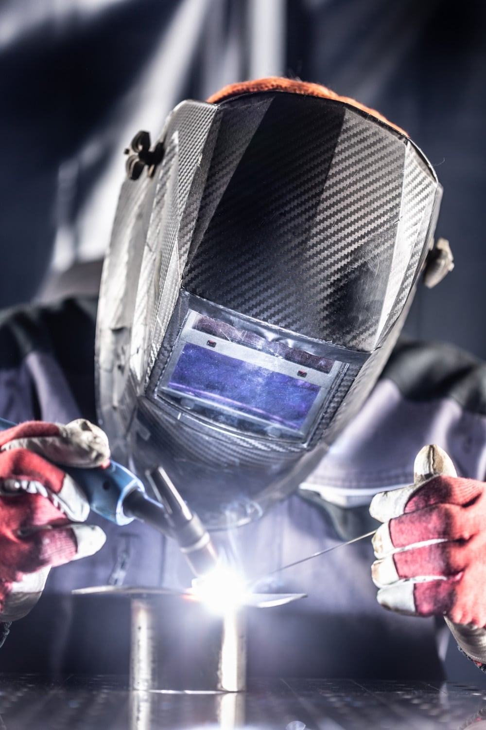 Welder industrial worker welding with argon machine.