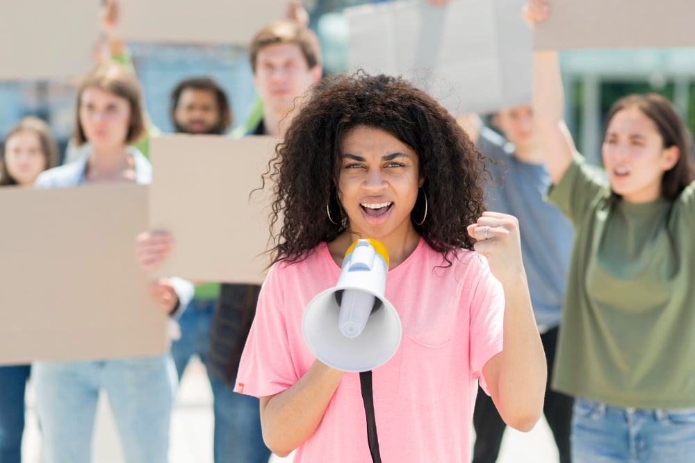 Woman with curly hair protesting with megaphone
