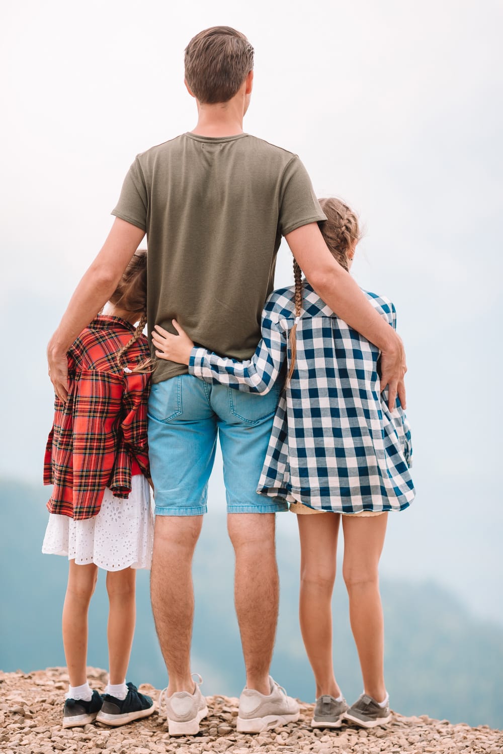 dad standing with his teenage children looking out over a scenic view showing connection and trust