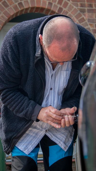 A locksmith works on unlocking a car, demonstrating his expertise and tools.