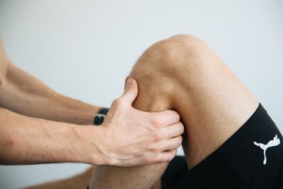 A man is doing a knee massage on a patient