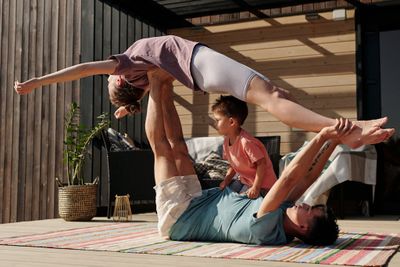 A Man Lying Down while Lifting a Woman