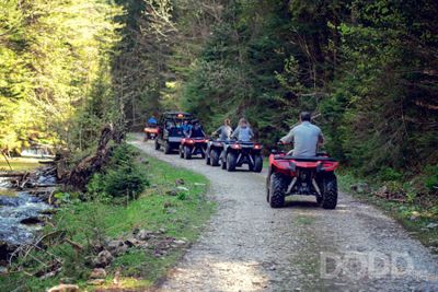 A tour group travels on ATVs and UTVs on the mountains